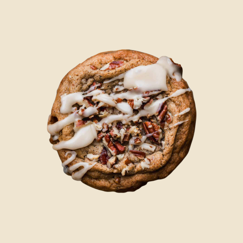 Cookie with white icing and pecans on a beige background
